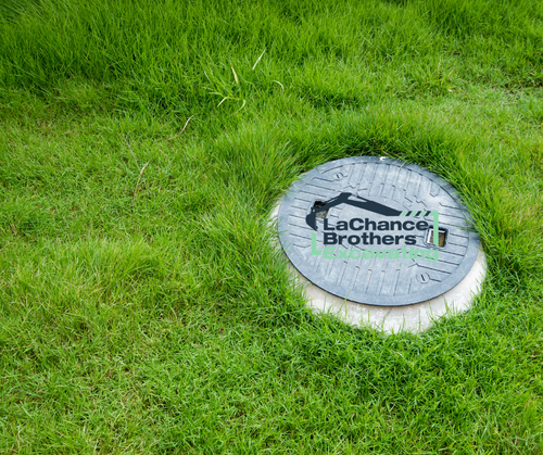 Tank lid in a lush green field
